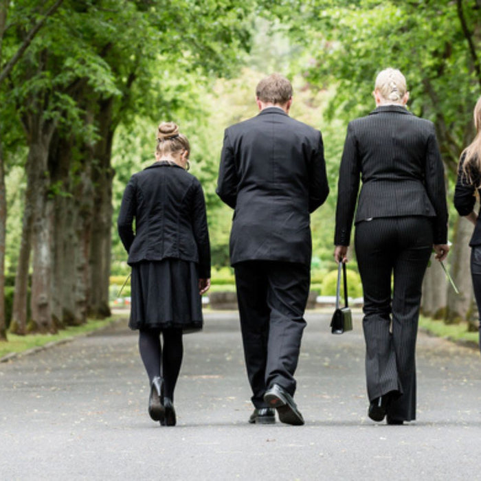 family walking down a path between trees